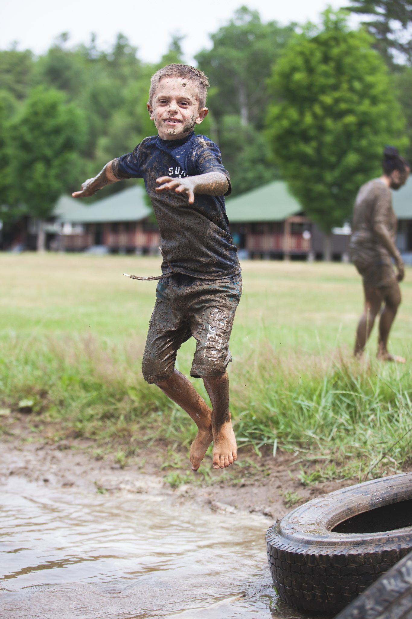Ranch boy jumping in mud