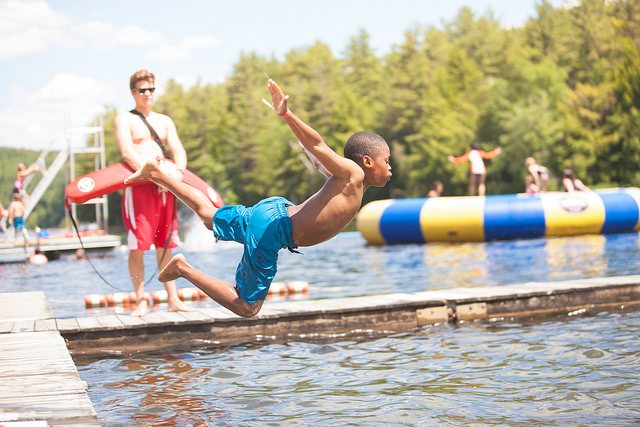 kid jumping into the lake from the dock.