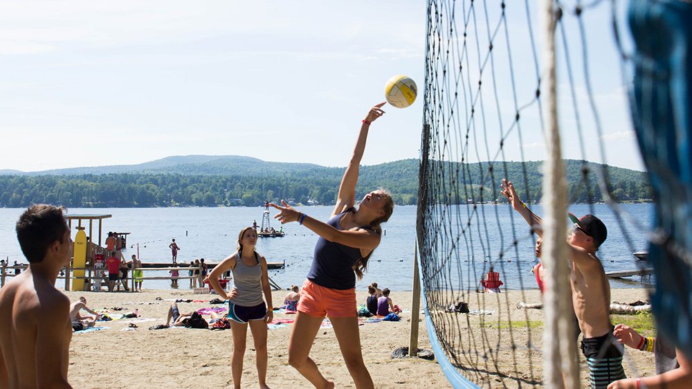 Teens playing beach volleyball.