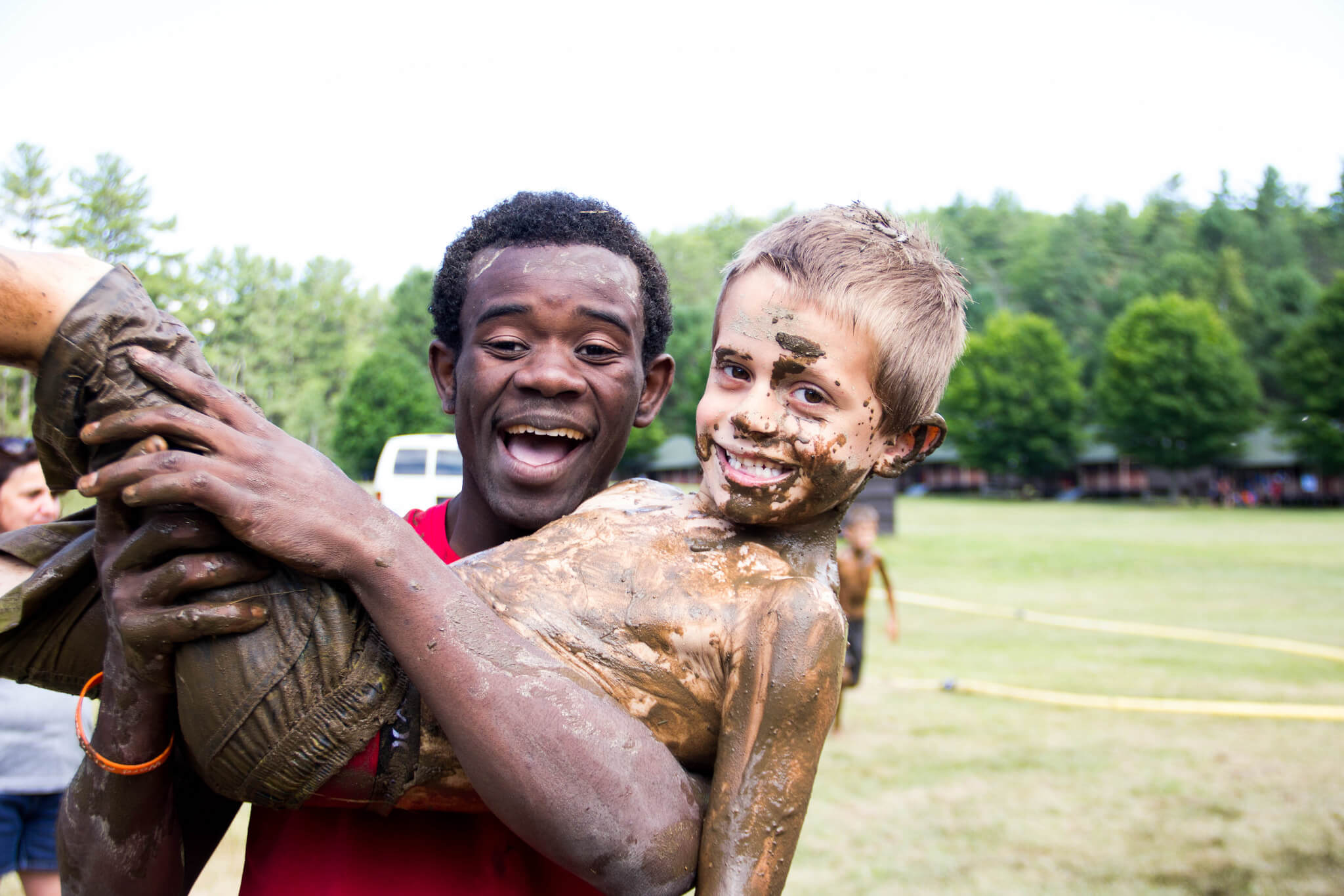 man holding child while covered in mud.