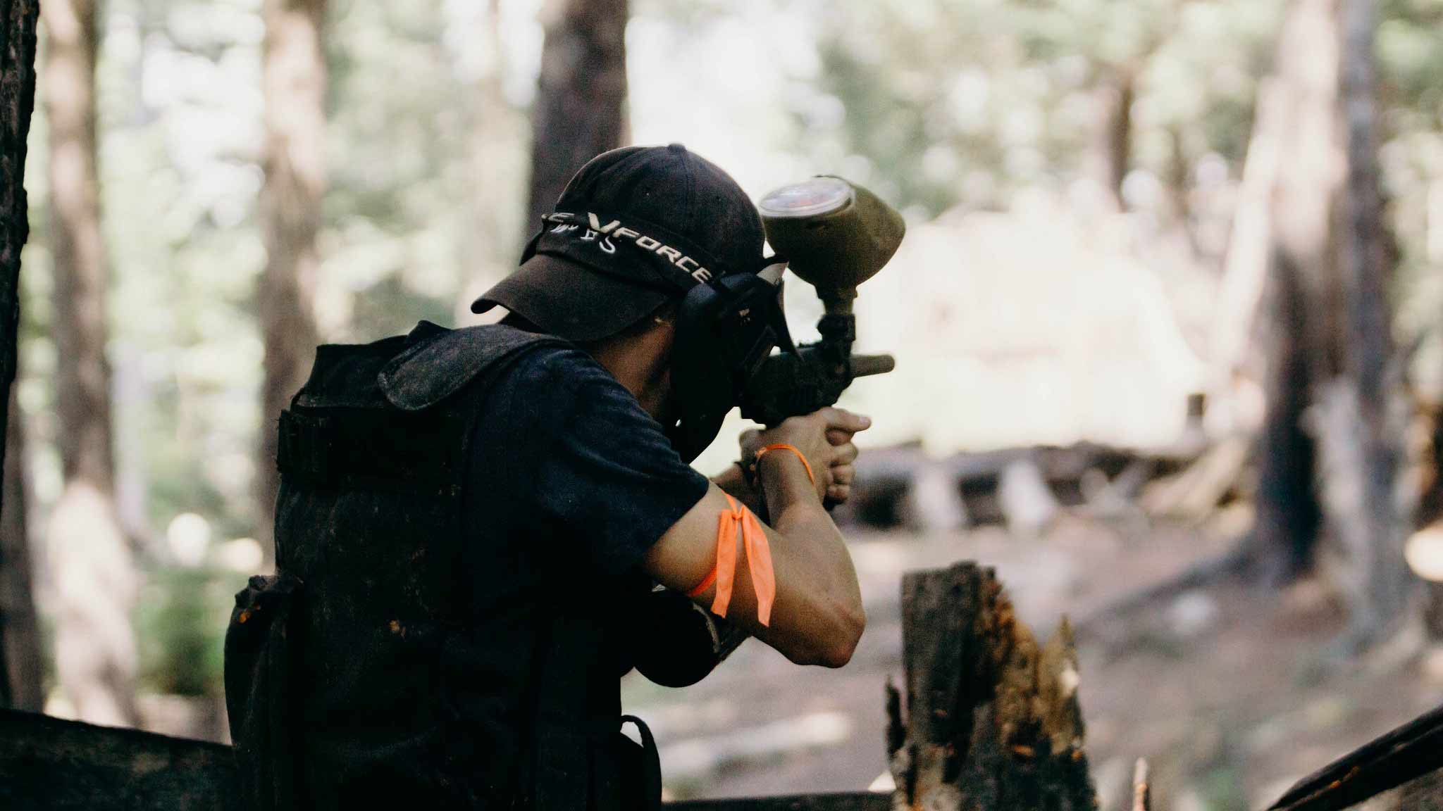 man playing paintball in the woods.