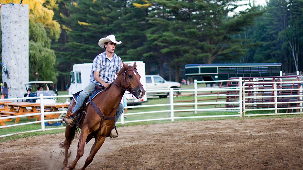 Man riding a western horse in a ring.