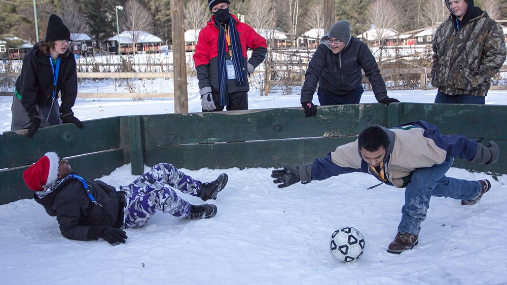 kids playing a game with a ball in the winter.