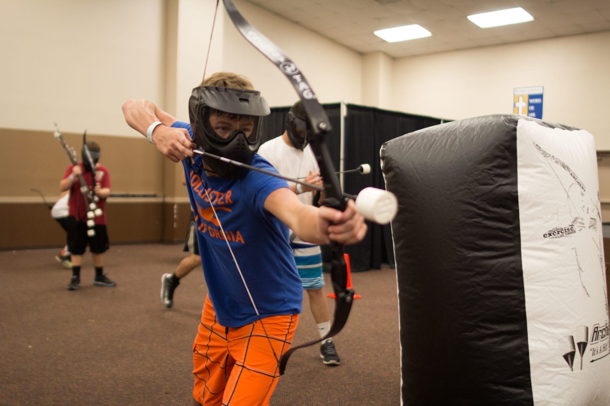 people playing archery tag indoors.